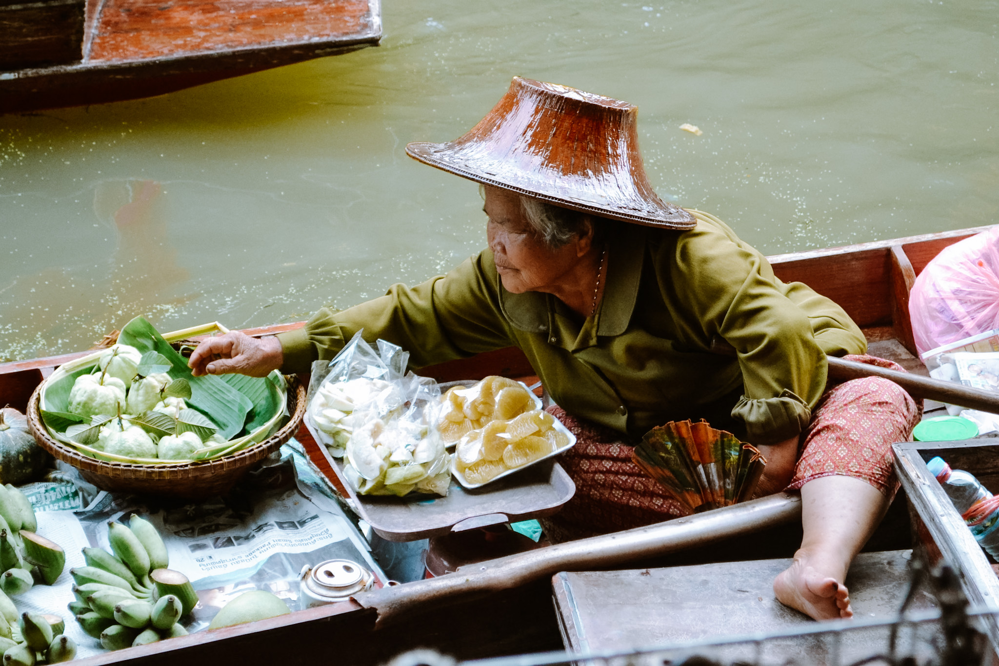 Een vrouw verkoopt fruit op de floating market in Thailand