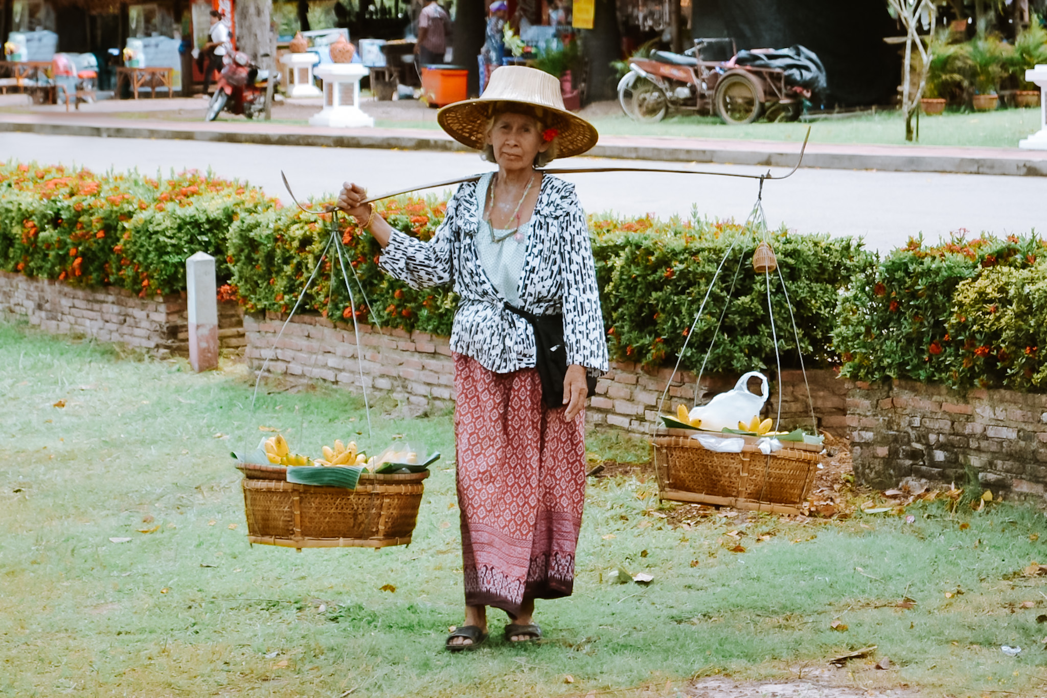 Thaise vrouw balanceert fruit op haar schouders