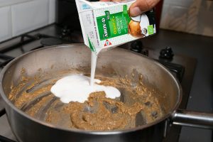 Kokosmelk toevoegen aan de gebakken groene currypasta.