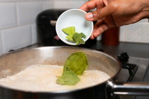 Limoenblad wordt toegevoegd aan groene currysaus.