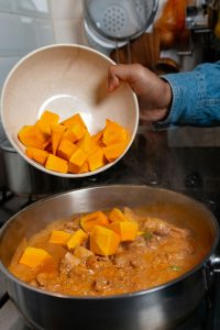 Pompoen wordt toegevoegd aan de saus van de Thaise Rode Curry.