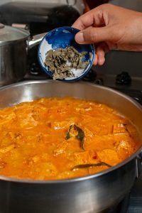 De Thaise Basilicum wordt toegevoegd aan de Thaise Rode Curry.