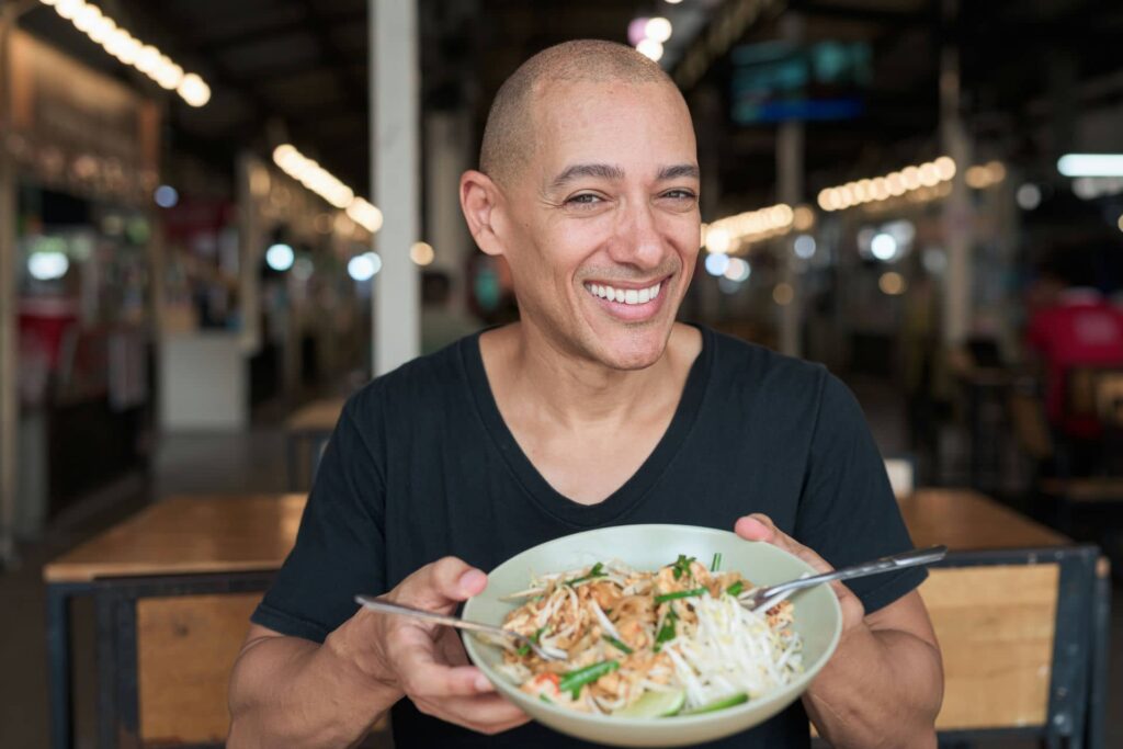 Thais eten - Man eet Pad Thai Noodles